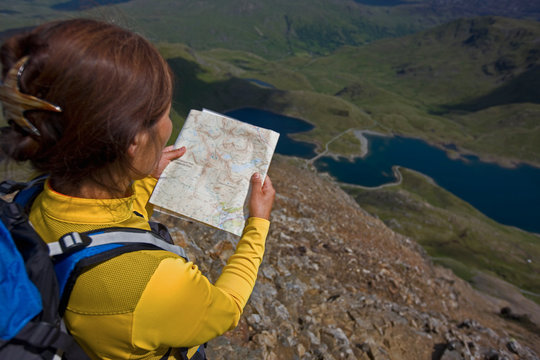 Woman reading a map on Snowdonia mountain