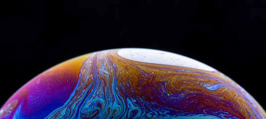 Burbuja de jabón simulando la atmosfera de un planeta con diferentes formas, colores y el fondo negro © Edgar1 BJ