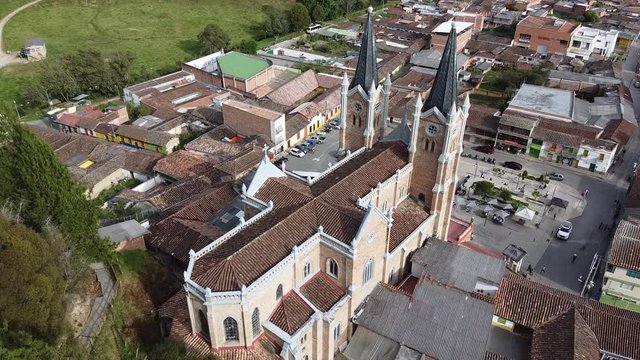Typical Antioquia Village with Big Catedral Surrounded of Green Hills of Pastures and Mountains Aerial View in Belmira, Antioquia / Colombia