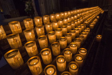 Burning candles in a painted glass in Notre-Dame de Paris.