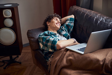 Obraz premium Cheerful young man resting on couch at home