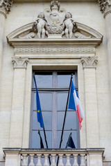 Window with flags on the Court of Cassation. Paris, France.