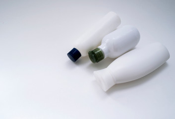 Jars of care products in white in various shapes and with different lids on a light background