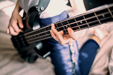 close up on the fingers of young girl playing bass guitar