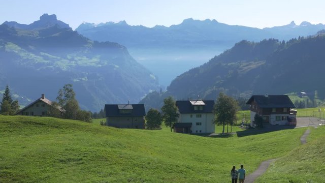 Couple holding hands on a walking path in the town of Stoos Switzerland.