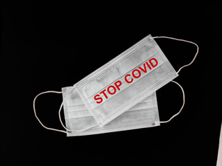Face masks to prevent Covid-19 virus or coronavirus with text STOP COVID on black background