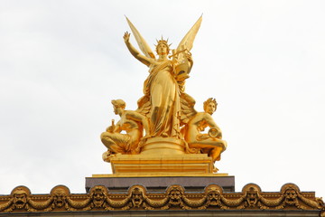 One of the two golden statues on the roof of the Opera House, Palais Garnier in Paris, France