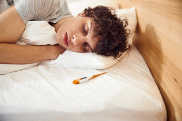 Handsome young man sleeping in bed at home