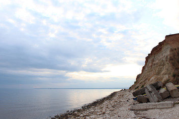 Fototapeta na wymiar Sea shore. Cloudy day. The stone coast.