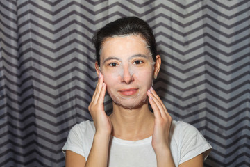 Girl in a cosmetic face mask. Makes homemade beauty treatments