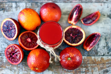 Selective focus. Macro. Red orange juice. Fresh juicy bloody oranges on a wooden surface.