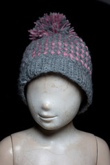 mannequin with a wool cap and a black background