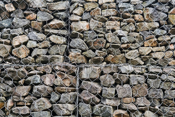 background - wire mesh gabion wall with granite boulders