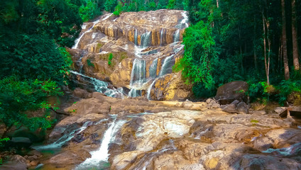 Fototapeta premium The waterfall running down the stream in the rain forest.