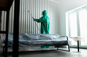 Chemical worker sanitizing the wall with chlorine spray stock photo