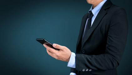 Businessman using a smartphone on dark background