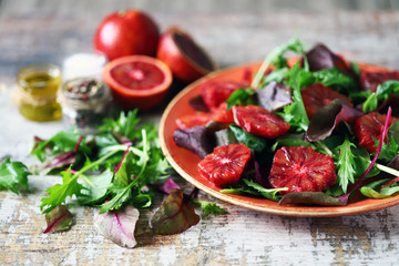 Selective focus. Macro. Healthy vegan mix salad with red oranges. Refreshing detox salad. Bloody orange. Cooking healthy food at home.