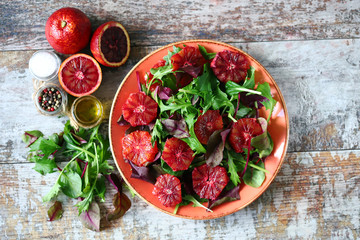 Selective focus. Macro. Healthy vegan mix salad with red oranges. Refreshing detox salad. Bloody orange. Cooking healthy food at home.