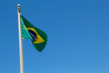 Bandeira do Brasil desgastada com o tempo no céu azul