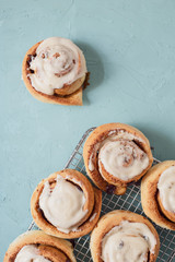 Rollos de canela caseros glaseados, en parrilla de horno sobre mesa color menta vista cenital, flat lay