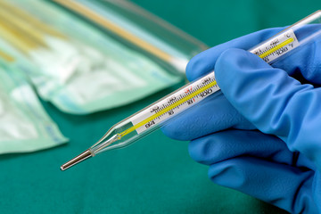 Oral thermometer and the medical staff's hand.