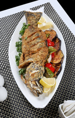 Deep oil fried whole seabass fish garnished with vegetable 