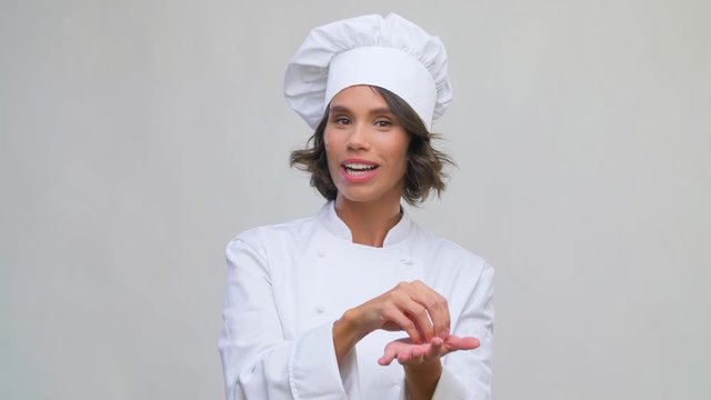 cooking, culinary and food blogging concept - happy smiling female chef in toque speaking to camera over grey background