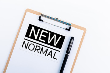 NEW NORMAL text - Blank paper on wooden clipboard with pen, white background, copy space