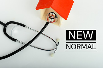 Concept of family medicine - Red Mini house and stethoscope isolated on white background with NEW NORMAL text