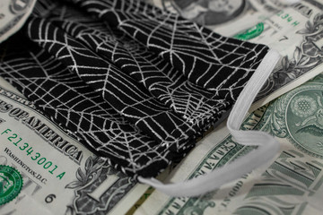US Dollar Bills and a Cloth Mask