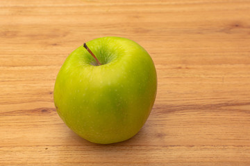 One green apple on wooden table. Healthy food. Fresh fruits.