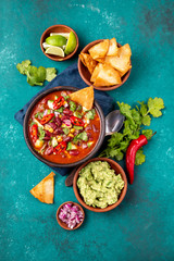 Mexican food concept background with chile black bean soup, guacamole and nachos totopos. Top view