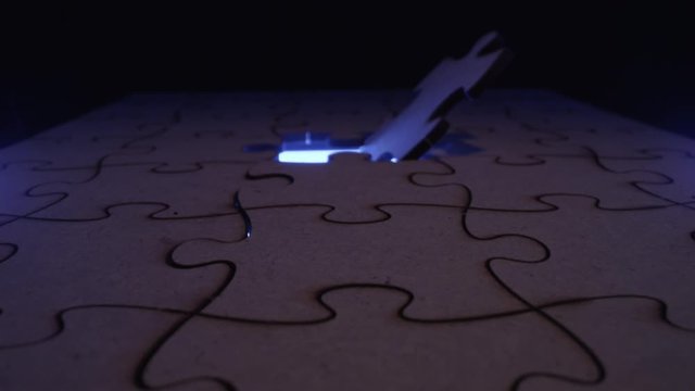 Jigsaw puzzle piece missing with light flashing through the open hole - symbolic element for Autism, business, problem solving, mystery and crime