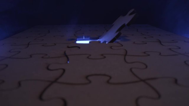 Jigsaw puzzle piece missing with light flashing through the open hole - symbolic element for Autism, business, problem solving, mystery and crime