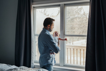 Middle age Caucasian father trying to calm down newborn baby. Man parent holding rocking child on...