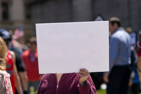 Woman hoding a white blank sign at a demonstration