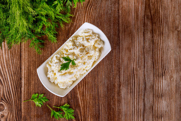 Cottage cheese in bowl on wooden background.