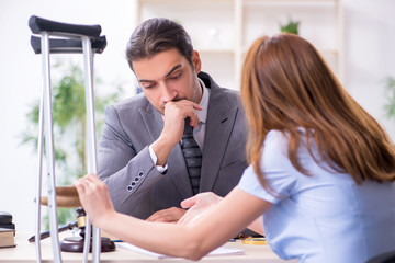 Young injured woman and male lawyer in the courtroom