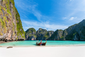Fototapeta na wymiar Tropical beach background. Panoramic views of Maya Bay with a longtail boat parked. overlooking white sand beach, clear water and beautiful sky. Phi Phi Leh island Krabi Province, Thailand.