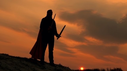 free male knight prays with swords outstretched hands. Superman with a sword in his hand and in red...