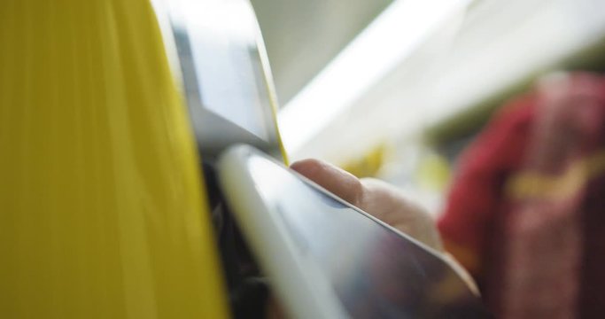 Close up of yellow bluetooth scanner of tickets in tram or bus. Woman scanning smartphone to pay for public transport. Payment by phone. Girl paying for trip.