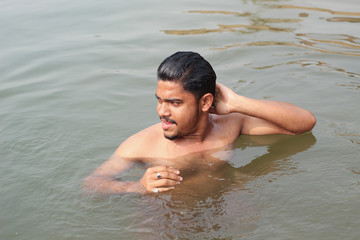 young man model bathing in a river