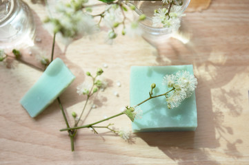 green blue home made soap and white flower on wood background organic health wellness skin care concept