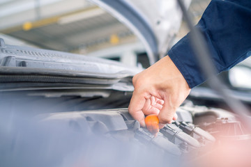 A close up of the hand auto mechanic repair engine in a car repair shop.