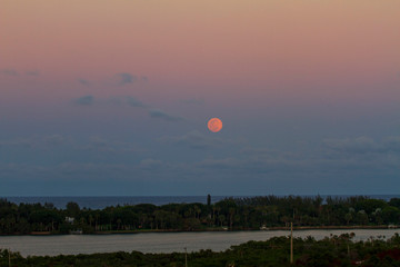 Full pink moon rising over the ocean