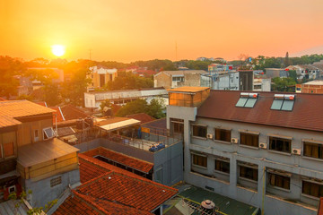 Fototapeta premium Urban skyline of the densely populated Bandung city in Java Island, Indonesia, with a warm sunset.
