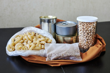food package with essentials in crisis. Pasta, buckwheat, rice, chickpeas, canned food, meat for donation to coronavirus