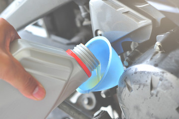 Refueling and pouring oil quality into the engine motorcycle Transmission and Maintenance Gear. Energy fuel concept.