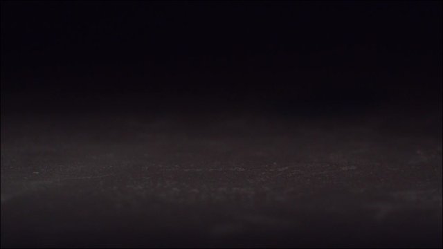 Egg falling and breaking  in slow motion on black tile surface. High speed 1600 frames per second.