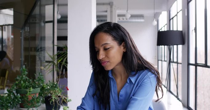 Zoom in on black female office worker installing application for editing corporate database working online on modern netbook, skilled company manager searching financial news on web page
